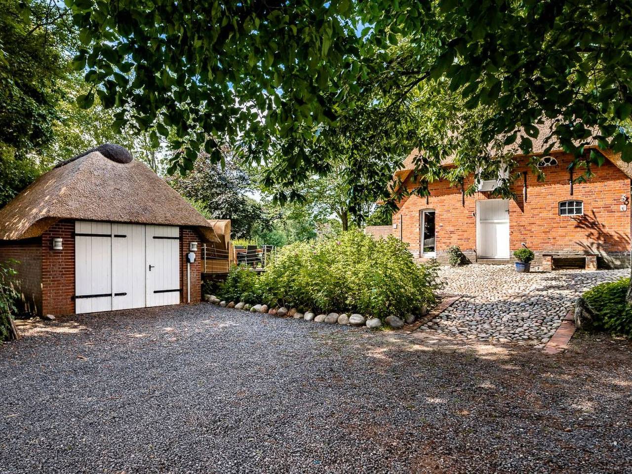 Reetdachhaus inmitten von Wiesen und Feldern in Emmelsbüll-Horsbüll, Nordfriesland