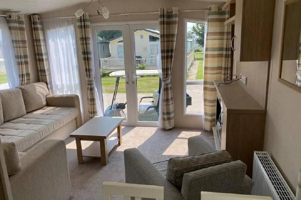 Caravan with front decking at Coopers Beach Holiday Park in Mersea Island, Colchester
