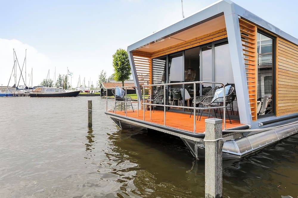 Houseboat Skoft with beautiful view over the water and on village Grou. in Nationalpark De Alde Feanen