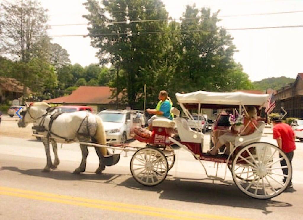 Downtown by Chattahoochee River, sit on front porch as horse and buggy stroll by in Helen, Chattahoochee National Forest