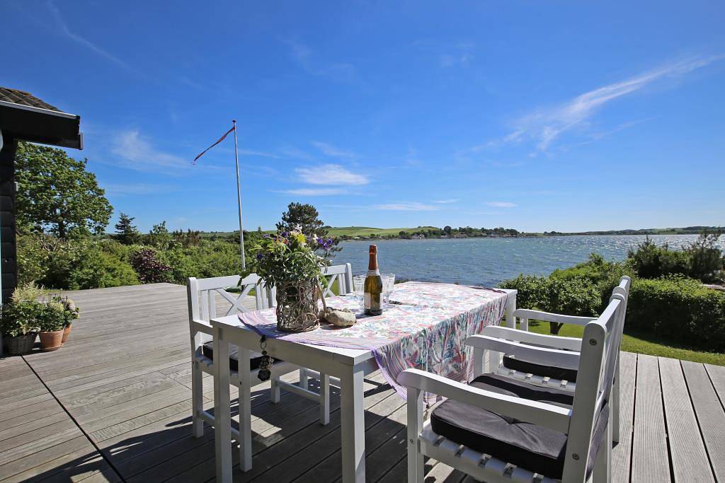 Wonderful beachfront holiday home with a large terrace and panoramic views of Knebel Cove – the perfect spot for tranquillity, nature and seaside living. in Knebel, South Djursland