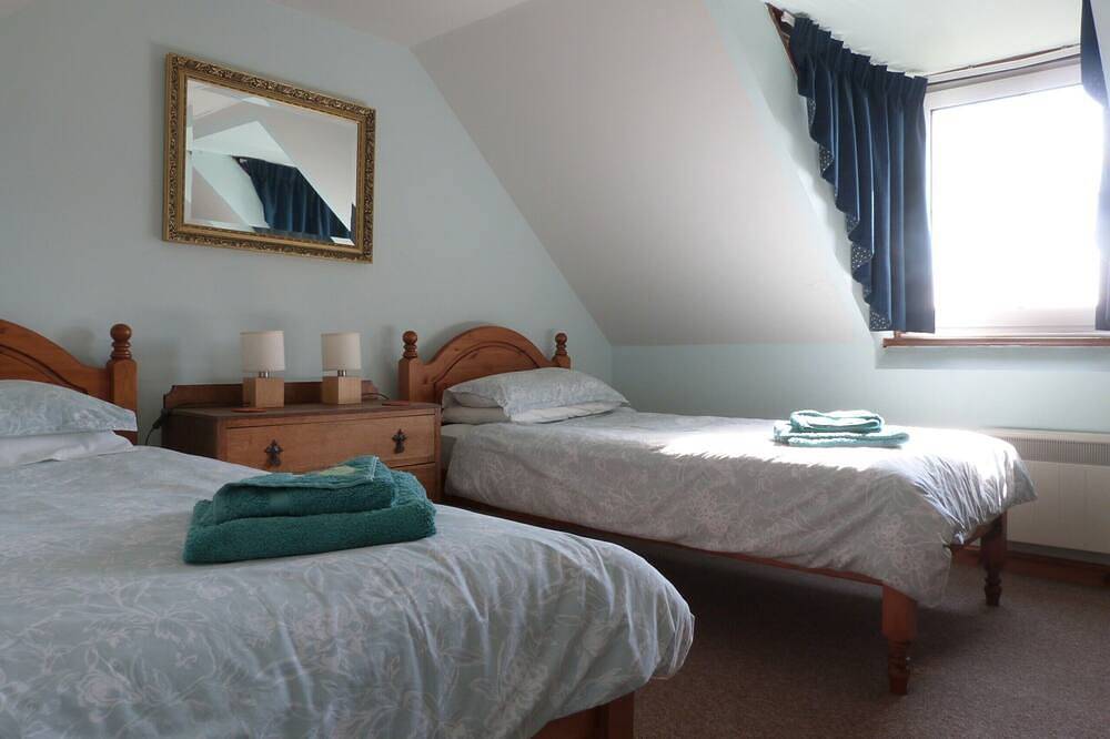 Traditionelles Hochlandhaus mit atemberaubendem Panoramablick auf die Berge und das Meer in Highlands