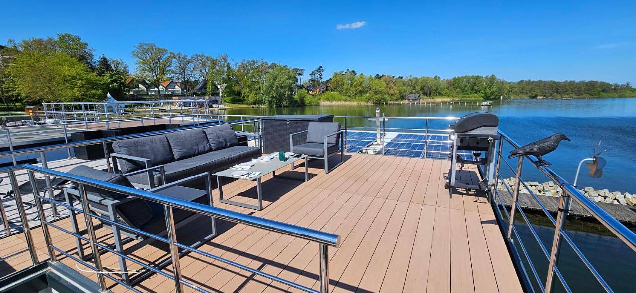 Modernes festliegendes Hausboot mit großzügiger Dachterrasse und Ruderboot in Röbel, Müritz