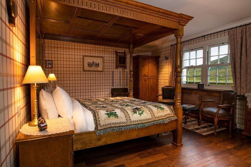 The wooden floors, vintage furniture, and tartan accents create a comfy room in Highlands