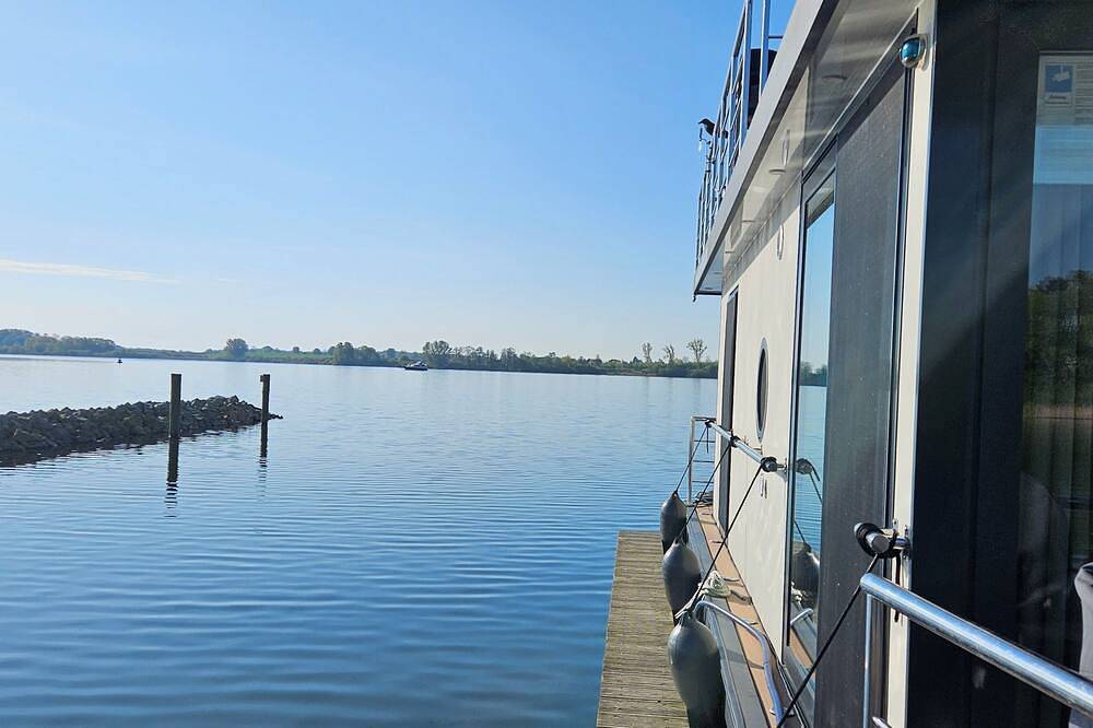 Modernes festliegendes Hausboot mit großzügiger Dachterrasse und Ruderboot in Röbel, Müritz