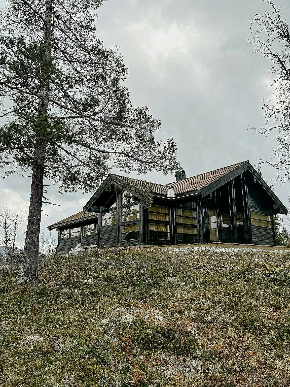 Fischerhütte mit Blick auf Moor und schneebedeckte Berge in Flå