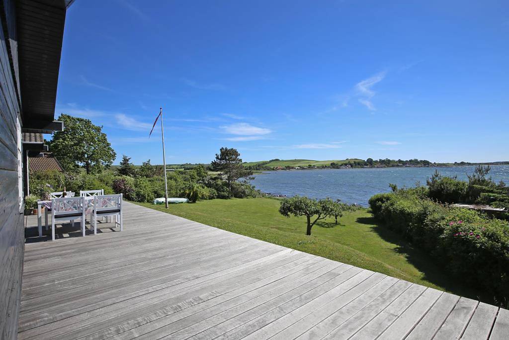 Wonderful beachfront holiday home with a large terrace and panoramic views of Knebel Cove – the perfect spot for tranquillity, nature and seaside living. in Knebel, South Djursland