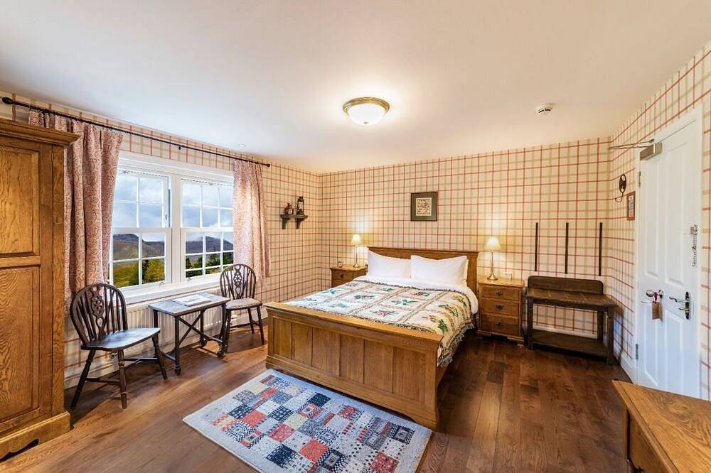 The wooden floors, vintage furniture, and tartan accents create a comfy room in Highlands