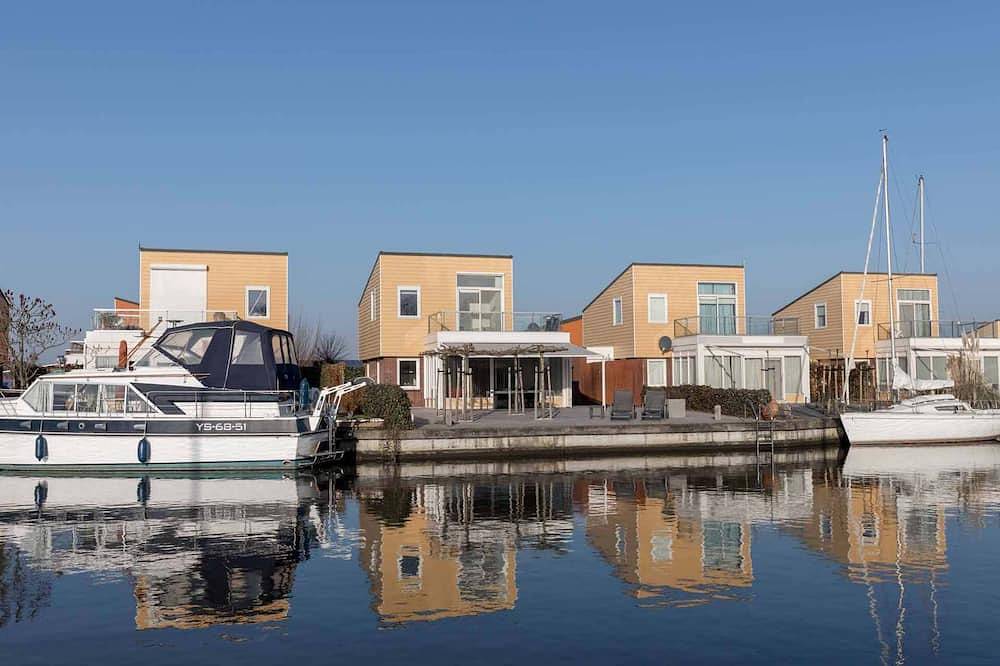 Luxus Ferienhaus mit vollständig geplatteter Terrasse an der Wasserseite. Unter der Terrassen-Überda in Oude-Tonge, Goeree-Overflakkee