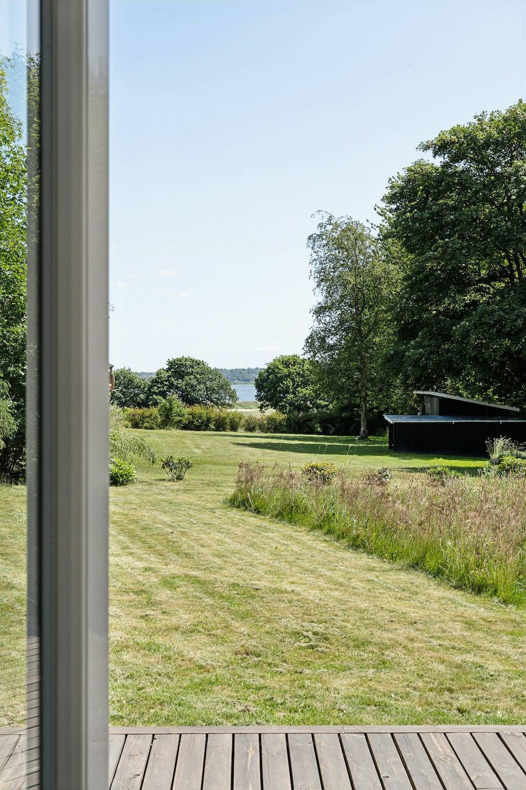 Boshuis met beekje bij Hjarbæk Fjord in Strandet, Limfjord in West-Jutland