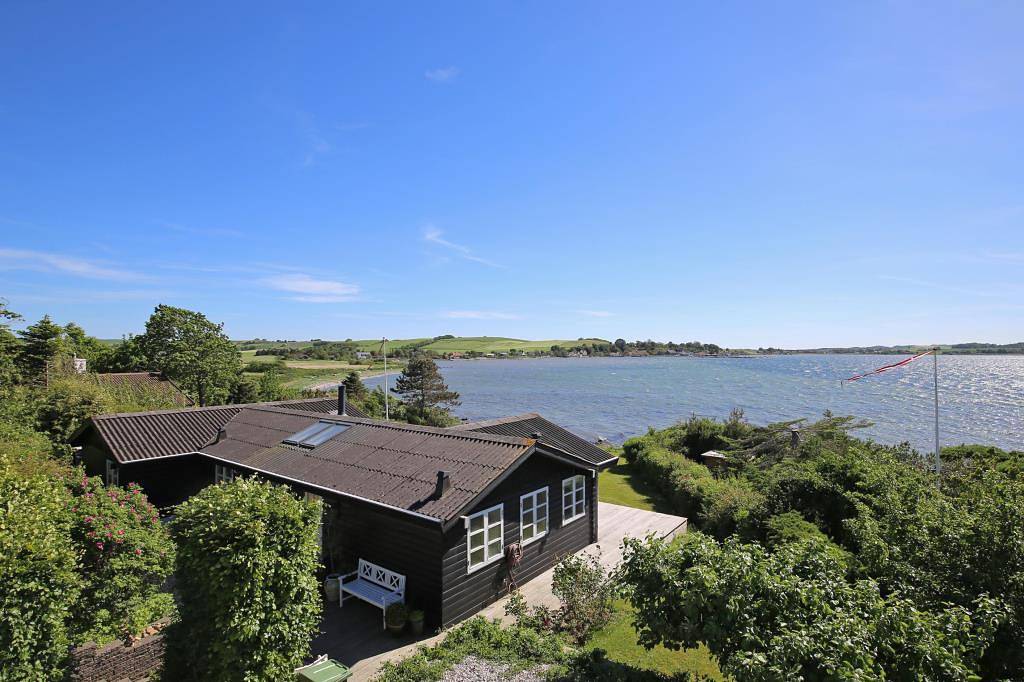 Wonderful beachfront holiday home with a large terrace and panoramic views of Knebel Cove – the perfect spot for tranquillity, nature and seaside living. in Knebel, South Djursland