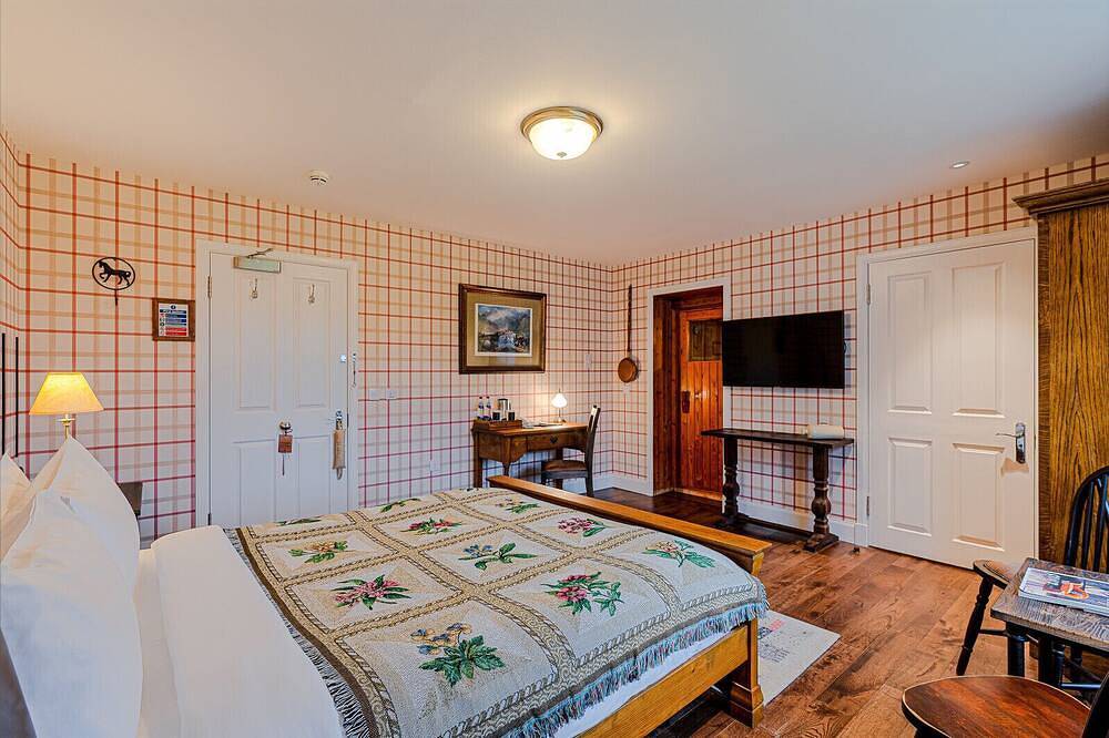 The wooden floors, vintage furniture, and tartan accents create a comfy room in Highlands