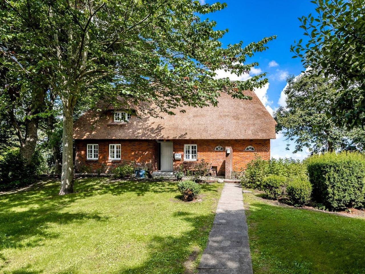 Reetdachhaus inmitten von Wiesen und Feldern in Emmelsbüll-Horsbüll, Nordfriesland