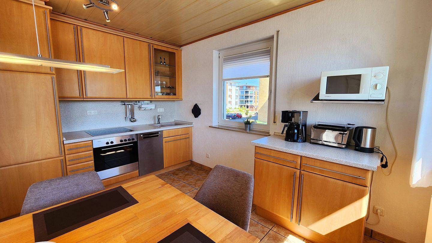Ganze Wohnung, Diese geräumige, gepflegte 3-Zimmer-Wohnung in der 1. Etage mit Balkon und traumhaftem Blick über den Binnensee ist aufgeteilt in Wohnbereich mit gemütlicher Eckcouch, Sessel und Couchtisch. in Steinwarder, Heiligenhafen