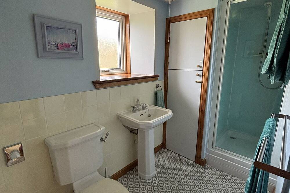 Traditionelles Hochlandhaus mit atemberaubendem Panoramablick auf die Berge und das Meer in Highlands