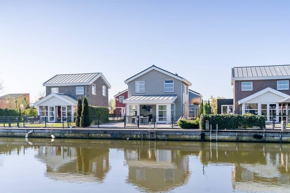 Dieses freistehende Inselhaus hat einen eigenen modernen Charme. Das Wohnzimmer befindet sich im Erd in Oude-Tonge, Goeree-Overflakkee