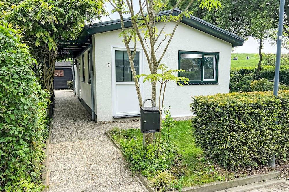 Kleine woning met tuin direct achter de dijk in Nederlandse Noordzeekust