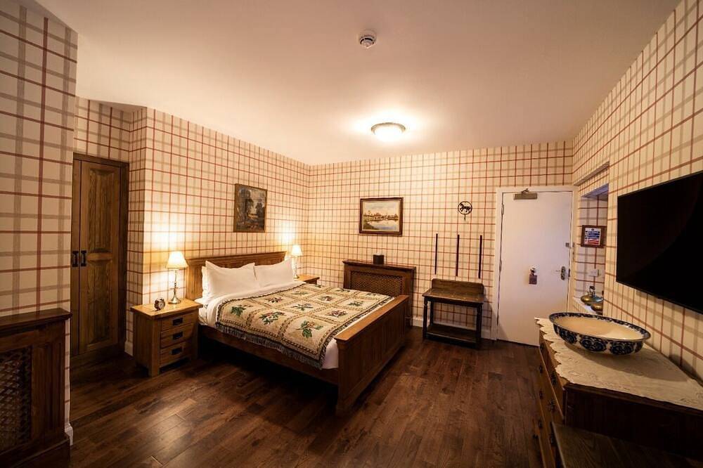 The wooden floors, vintage furniture, and tartan accents create a comfy room in Highlands