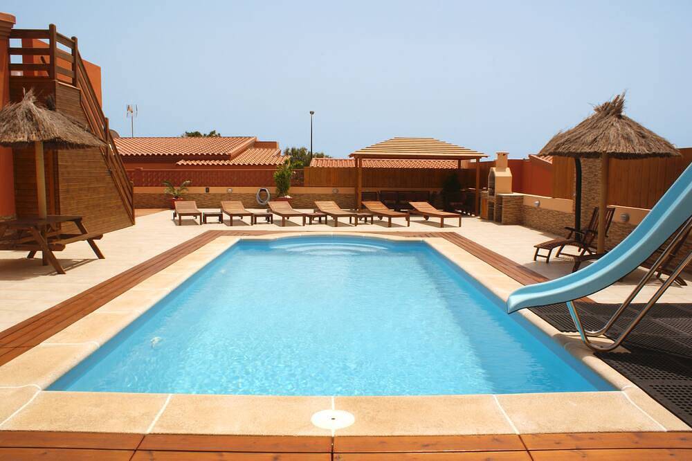 Villa de 4 dormitorios en la ciudad, piscina de 10 m con tobogán para niños, valla de seguridad, barbacoa, salones al aire libre in Caleta de Fuste, Antigua