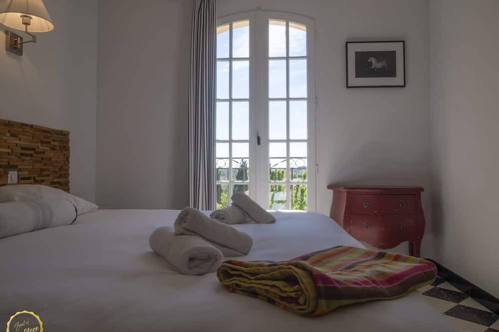 Mas Provençal first floor living room with fireplace and veranda overlooking Alpilles- Vallée des Baux in Paradou, Arles region
