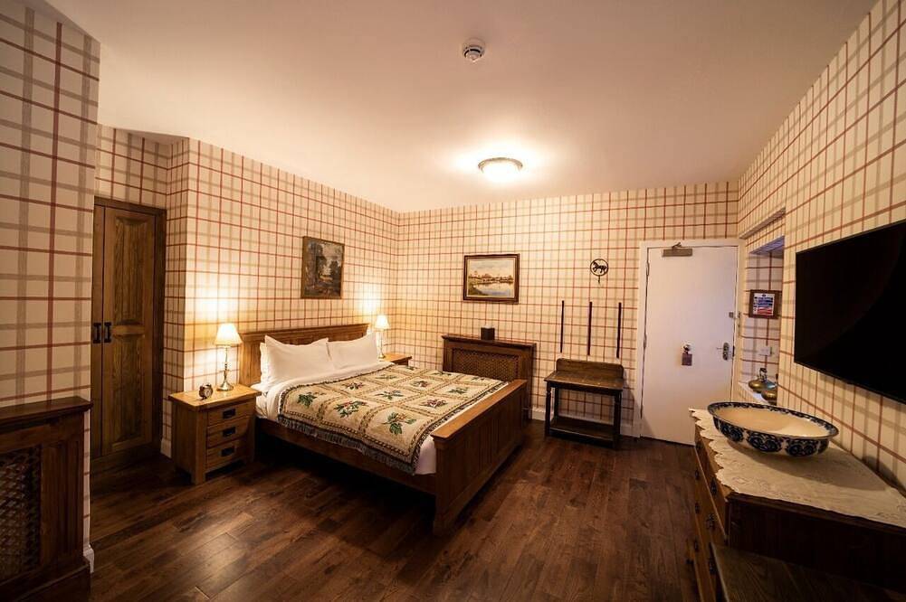 The wooden floors, vintage furniture, and tartan accents create a comfy room in Highlands