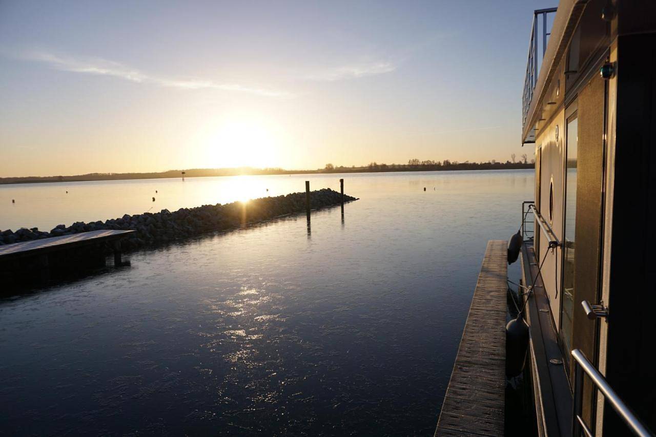 Modernes festliegendes Hausboot mit großzügiger Dachterrasse und Ruderboot in Röbel, Müritz