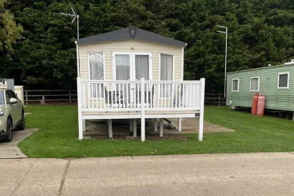 Caravan with front decking at Coopers Beach Holiday Park in Mersea Island, Colchester