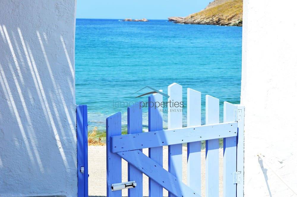 Casa in pietra originale sul lungomare con accesso a una grande spiaggia sabbiosa in Otzias, Kea