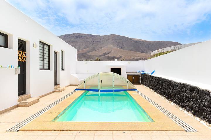Casa de playa Famara en la orilla con piscina compartida, vistas al mar/montaña y Wi-Fi in Playa de Famara, Teguise