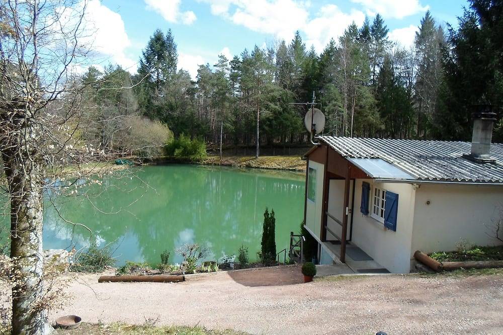 Chalet con vistas a un estanque en un entorno verde. in Augignac, Parque Natural Regional Périgord-Limousin