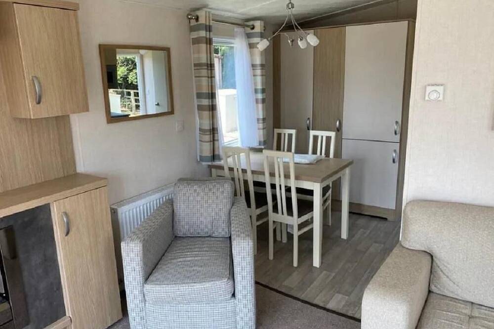 Caravan with front decking at Coopers Beach Holiday Park in Mersea Island, Colchester