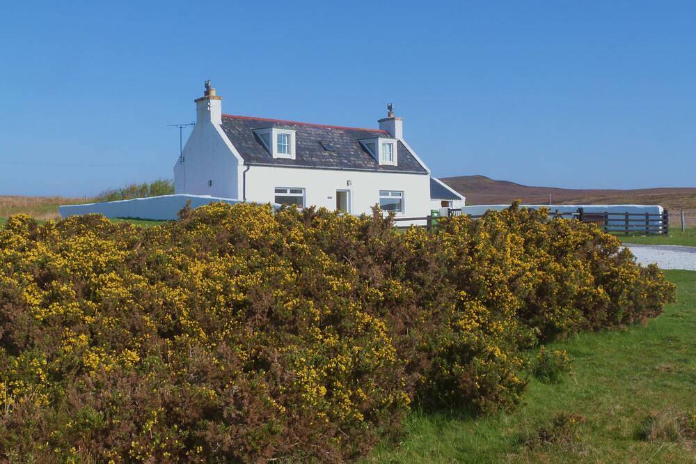 Traditionelles Hochlandhaus mit atemberaubendem Panoramablick auf die Berge und das Meer in Highlands