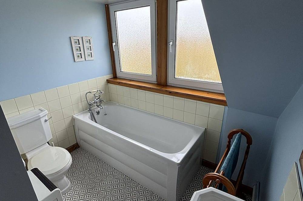 Traditionelles Hochlandhaus mit atemberaubendem Panoramablick auf die Berge und das Meer in Highlands