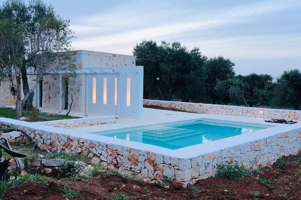 White stone typical apulian villa with barrel roof surrounded by olive trees. in Ostuni, Salento