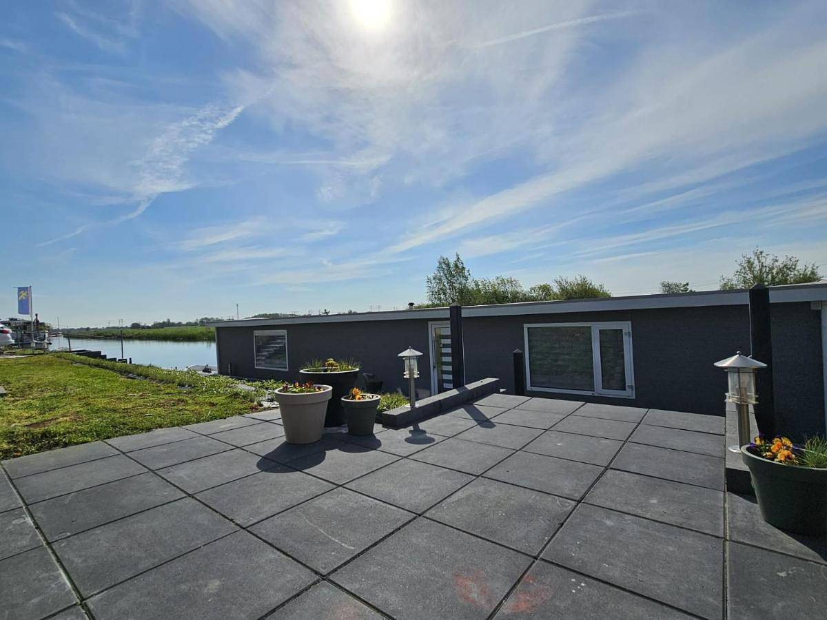 Luxe woonboot in de natuur aan doorgaand vaarwater in Leeuwarden, Nederlandse Noordzeekust