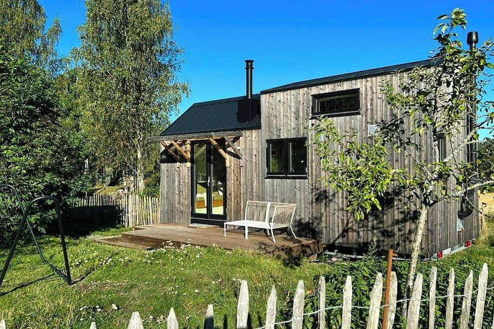 Ein Mikrohaus in einem Rosengarten auf einem kleinen Bauernhof in Frogn