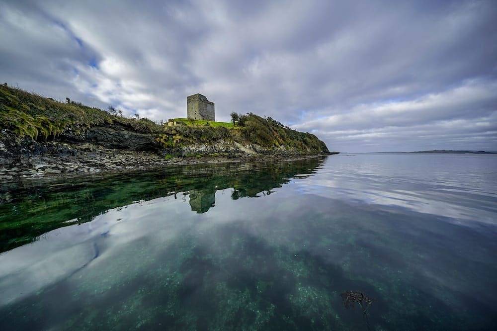 Historischer Turm auf den Klippen an der 'Roaring Water' Bucht. in Munster